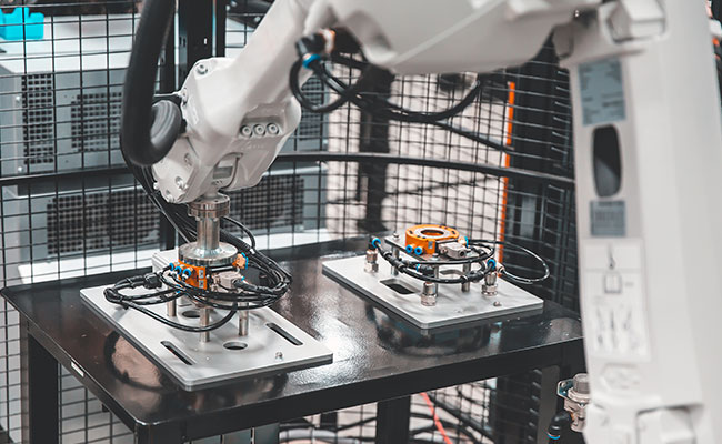 Industrial robotic arm assembling mechanical components on a production line in a modern automated factory.